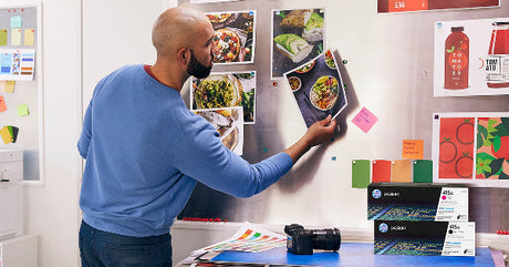 a photographer admires his photographic prints from his hp printer