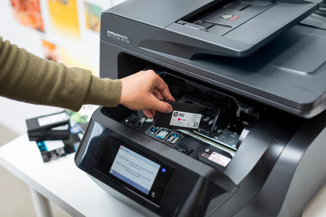 a man removes an ink cartridge from his hp officejet pro printer