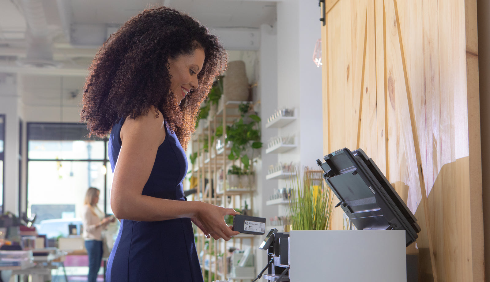 a lady replaces her printer ink with a brand new genuine ink cartridge from HP