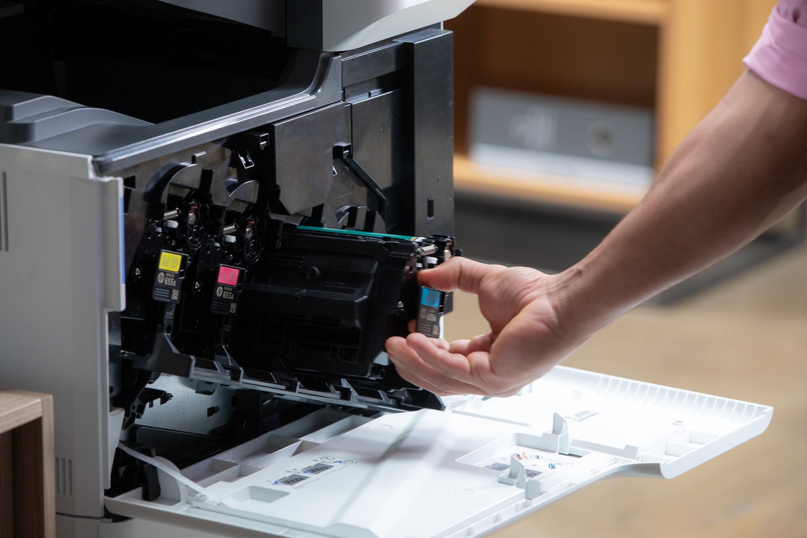 a cyan toner cartridge is removed from a printer in an office