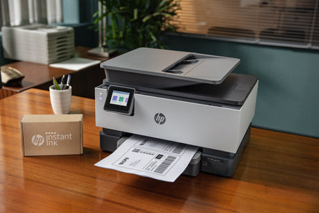 box of newly delivered instant ink from hp next to a home printer