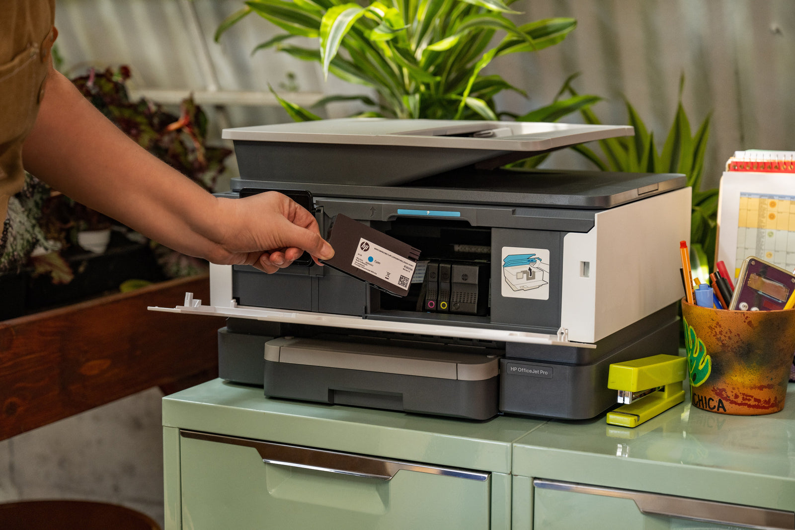 a lady reloads her printer ink in her green eco-friendly home office space