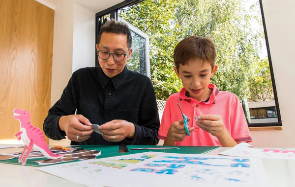 father and son do arts and crafts with materials downloaded from the canon creative park app