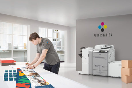 a man works in the office with his laser printer in the background