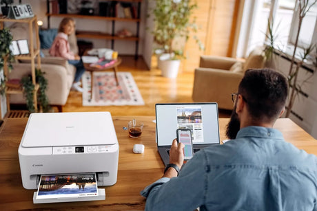 a man prints his travel itinerary with his Canon PIXMA TS6550i printer