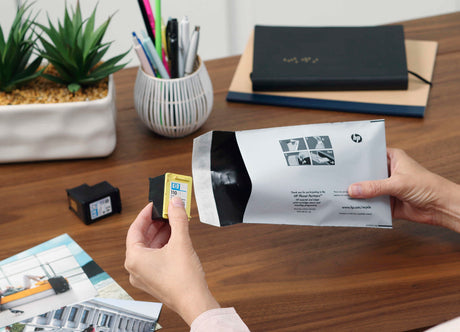 woman inserts her old empty ink cartridges into a free recycling envelope from crazy kangaroo